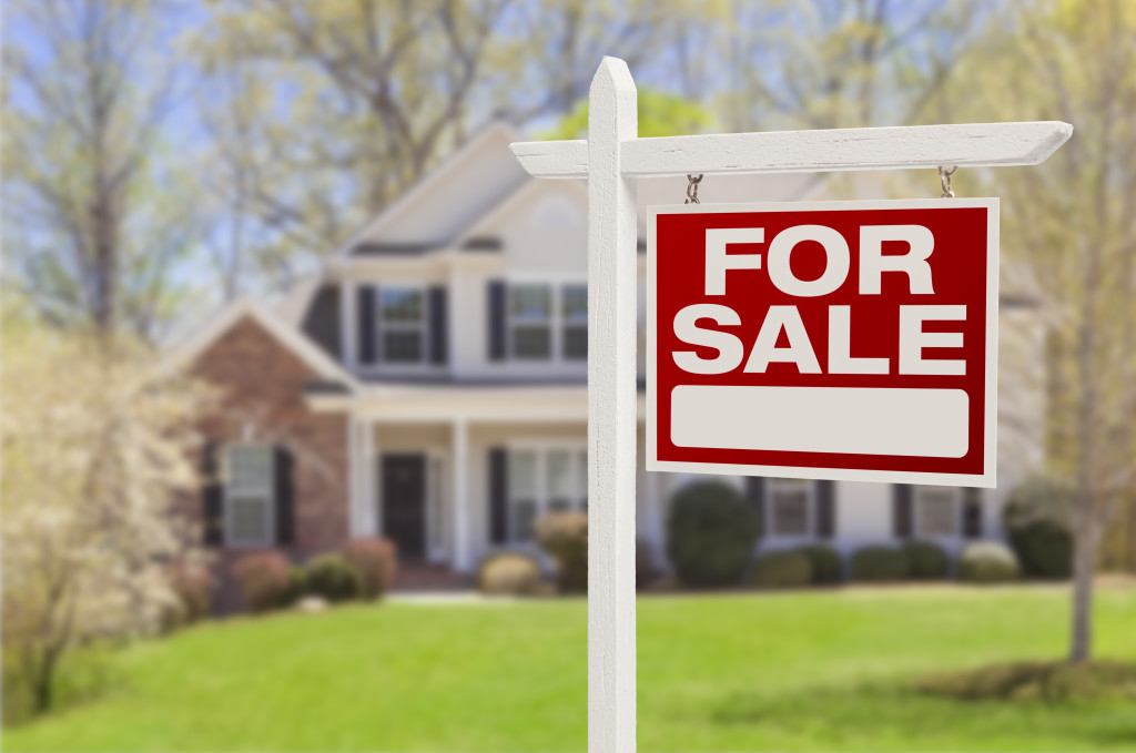Home For Sale Real Estate Sign in Front of Beautiful New House.